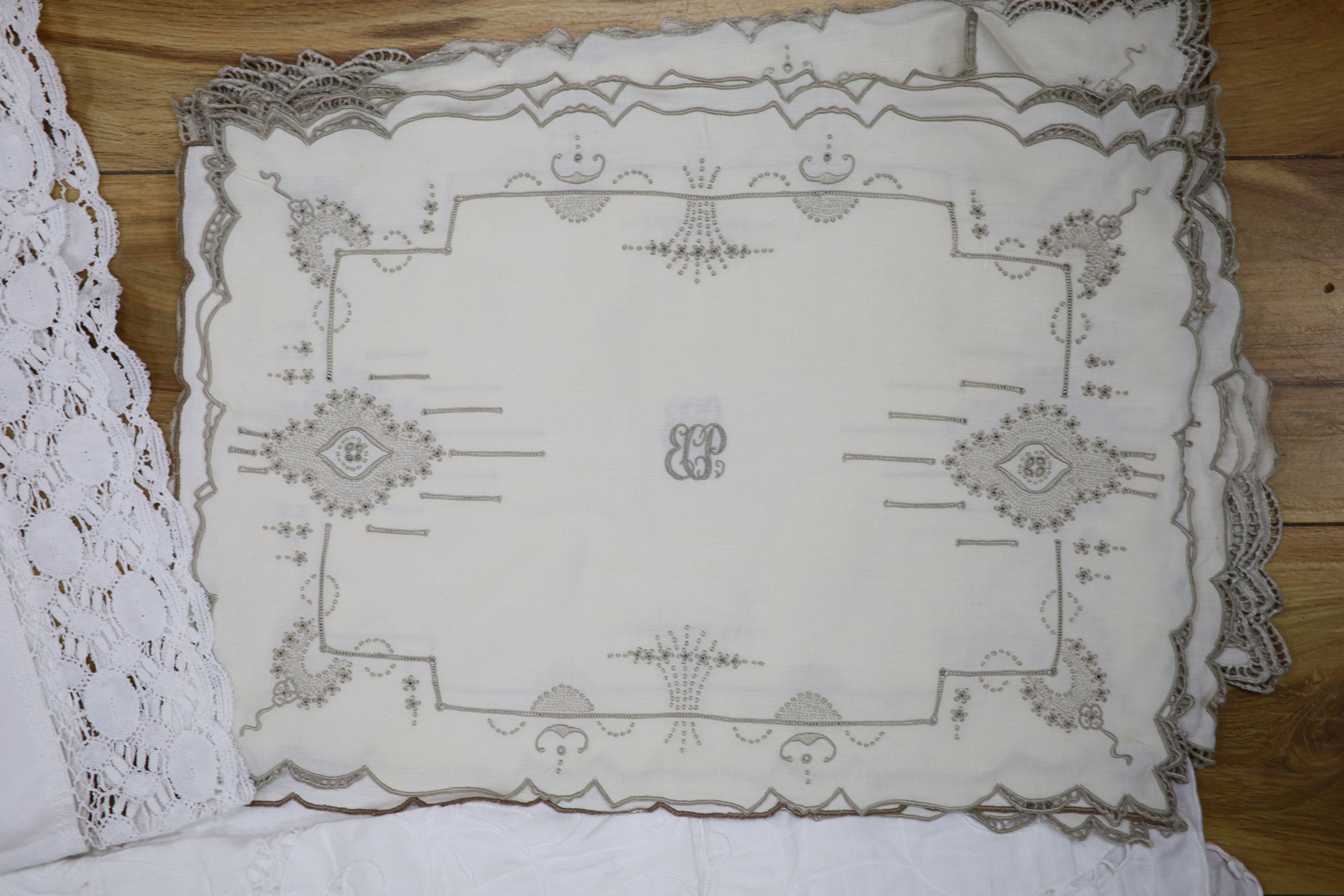 A large cutwork tablecloth, pillowcase plus a napkin and table mat set